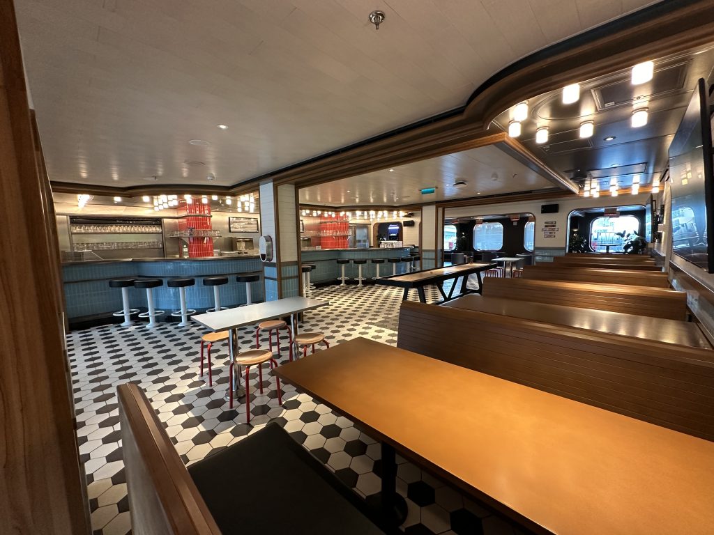 A 50's themed "soda shoppe" with a black, white, and red styled wooden booths.